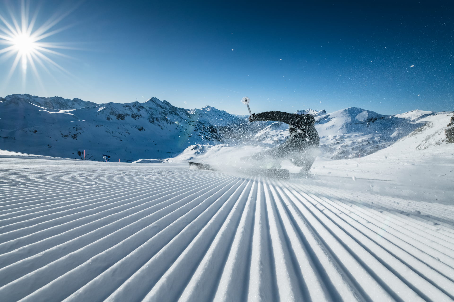 Skifahrer beim Carven auf den frisch präparierten Pisten der Skiregion Obertauern während der sportlichen Vorweihnachszeit