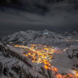 Blick auf den beleuchteten Ort Obertauern im Winter bei Nacht