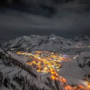 Blick auf den beleuchteten Ort Obertauern im Winter bei Nacht