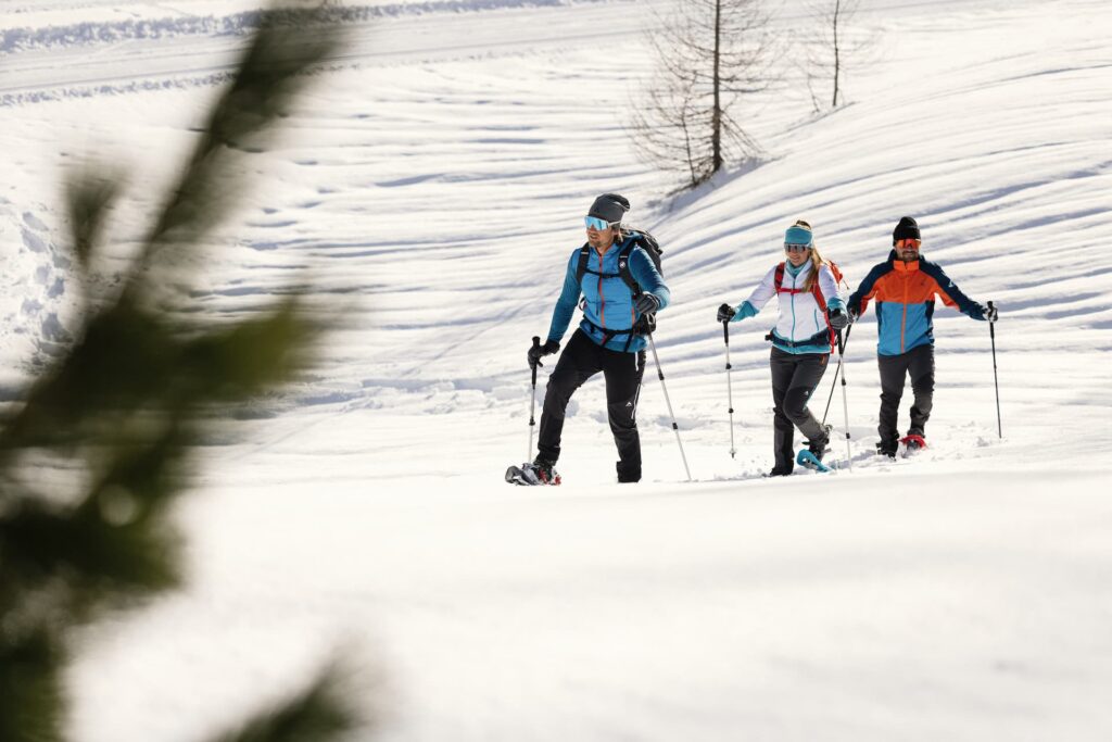 Eine kleine Gruppe beim Schneeschuhwandern in der verschneiten Winterlandschaft Obertauerns