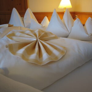 Liebevoll dekoriertes Doppelbett im Zimmer des Hotel Koch Obertauern